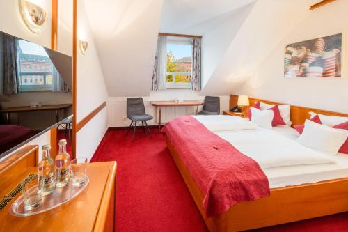 a small room with a bed and a table at Hotel Blumlage in Celle