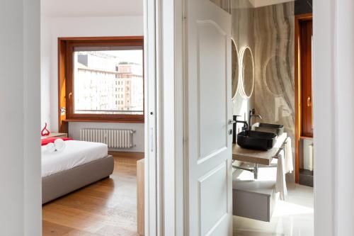 1 dormitorio con cama, escritorio y ventana en FREE Parking - 5 Star - Sauna Luxury Apartment, en Milán