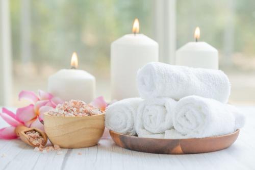 a pile of towels and candles on a table at Staybridge Suites Dubai Internet City by IHG in Dubai
