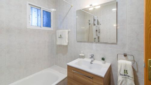 Baño blanco con lavabo y espejo en Villa Quevedo Torrox by Ruralidays, en Torrox