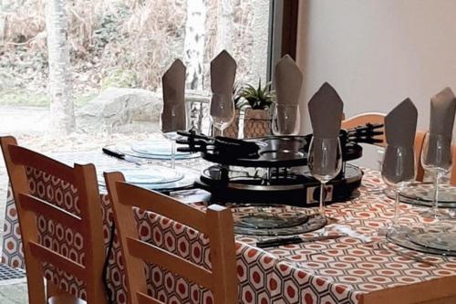 a dining room table with plates and glasses on it at Cottage-4p-Les Hauts de bruyère-293 in Chaumont-sur-Tharonne