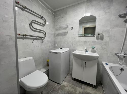 La salle de bains blanche est pourvue de toilettes et d'un lavabo. dans l'établissement Narva Apartment AV, à Narva