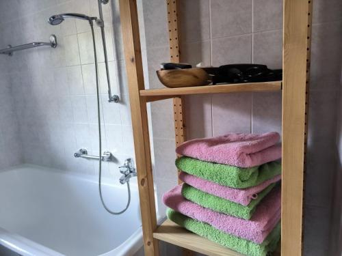 une pile de serviettes sur une étagère dans une salle de bains dans l'établissement Ferienwohnung Straußstrasse, à Bayerisch Gmain