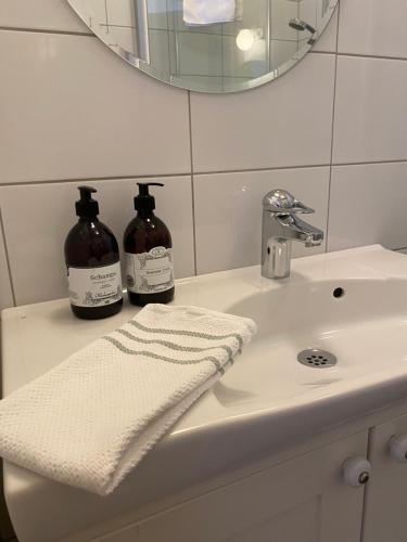 a bathroom sink with a mirror and a towel at Hälsingegården Erik-Anders in Söderhamn