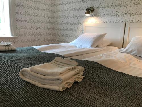 a pile of towels sitting on top of two beds at Hälsingegården Erik-Anders in Söderhamn