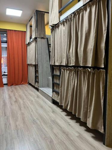 Zimmer mit Vorhängen an der Wand in der Unterkunft РОЙ in Almaty