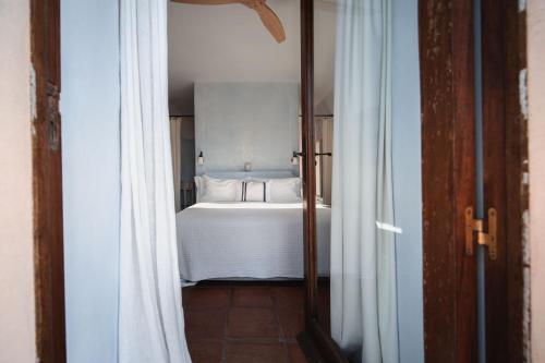 a view of a bedroom with a bed and a mirror at ES CUCONS RURAL HOTEL in San Antonio