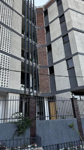 un grand bâtiment avec une clôture devant lui dans l'établissement Annaye Apartment, à Addis-Abeba