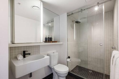 een badkamer met een toilet, een wastafel en een douche bij The Sweet Escape - Chic Apartment with Rooftop Pool in Melbourne