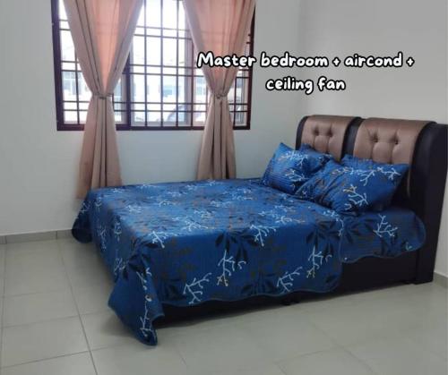 Bemban的住宿－Umar's Lodge，一间卧室配有一张带蓝色棉被和枕头的床