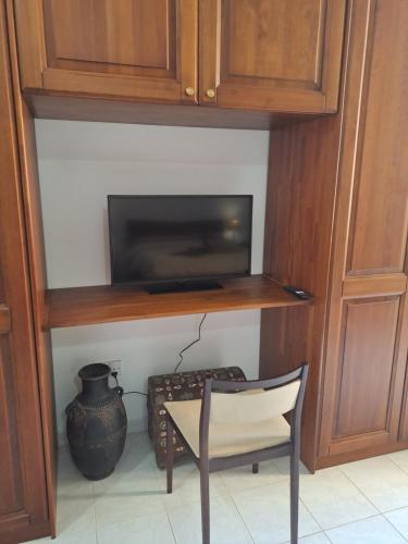 a chair in a room with a tv and a vase at The Misraħ at Rabat in Rabat
