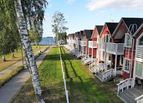 a row of houses with white chairs on the grass at Saimaa Seasons Marina Villas in Imatra