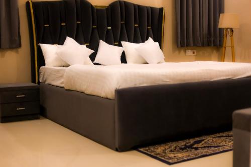 a bedroom with a large bed with white pillows at Luxuria Farmstays in Jaipur