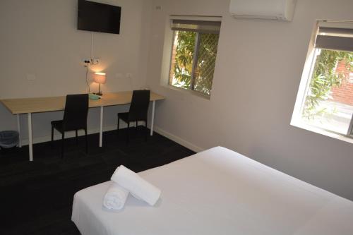 a hotel room with a bed and a desk with chairs at City Waters in Perth