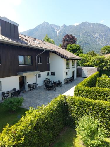 uma casa com um pátio com mesas e cadeiras em Bader Suites em Garmisch-Partenkirchen