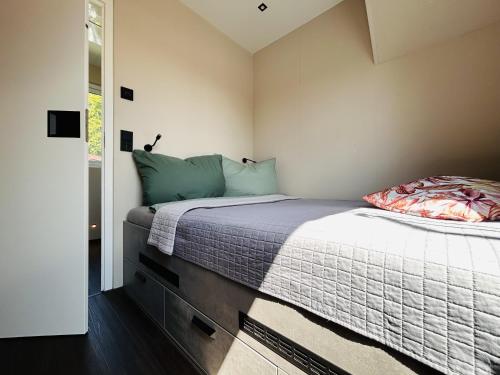 ein Schlafzimmer mit einem großen Bett mit blauen Kissen in der Unterkunft Hausboot Charlottenburg in Zeuthen