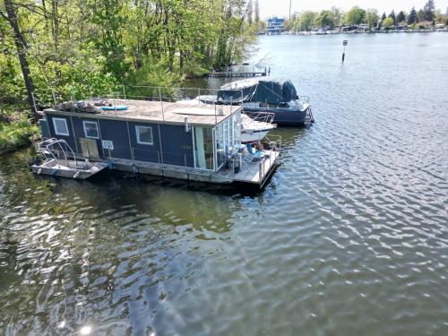 two boats are docked at a dock on a lake at Hausboot Insel Valentinswerder Berlin in Berlin