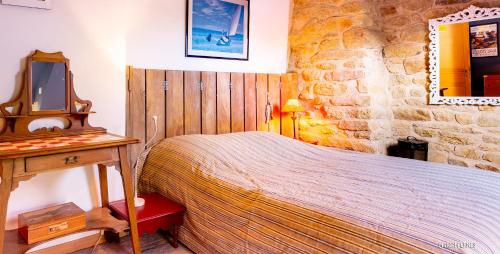 Schlafzimmer mit einem Bett, einem Tisch und einem Spiegel in der Unterkunft RÉF 401 - PLOEMEUR maison authentique et chaleureuse in Ploemeur