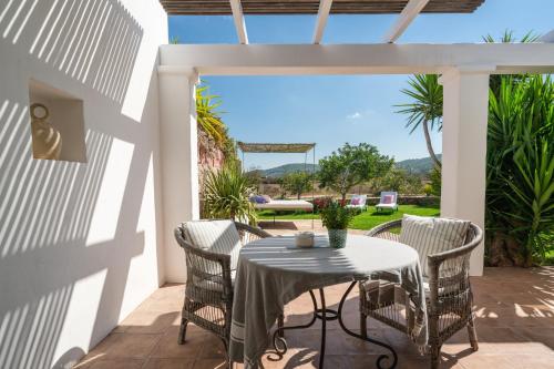 einen Tisch und Stühle auf einer Terrasse mit Aussicht in der Unterkunft ES CUCONS RURAL HOTEL in Sant Antoni de Portmany