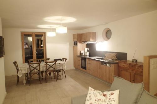 une cuisine et une salle à manger avec une table et des chaises dans l'établissement Appartement Etendard au Clos Marie, au Monêtier-les-Bains