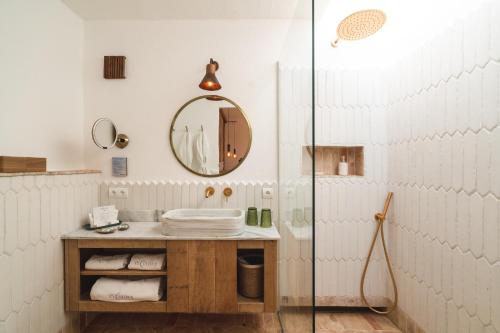 W łazience znajduje się umywalka i lustro. w obiekcie ES CUCONS RURAL HOTEL w mieście San Antonio
