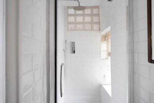 a white bathroom with a shower and a sink at The Mews Flat, near Clifton Suspension Bridge in Bristol