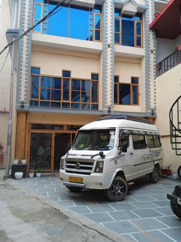 a white van parked in front of a building at Hotel CM Palace - Pure Vegetarian in Ner Chowk