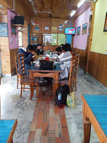 a group of people sitting at a table in a restaurant at Hotel CM Palace - Pure Vegetarian in Ner Chowk