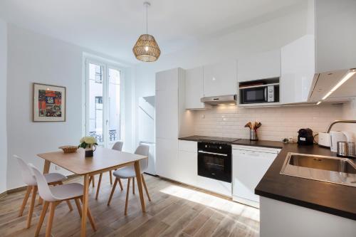 Il comprend une cuisine avec une table en bois et du parquet. dans l'établissement Cannes centre, climatisé, balcon, tout à pied, à Cannes