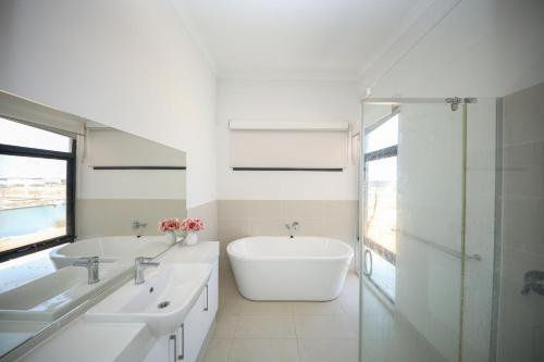 a bathroom with two sinks and a tub and a shower at Exmouth Marina Escape in Exmouth