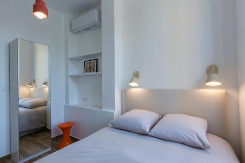 - une chambre dotée d'un lit avec des draps blancs et des lumières dans l'établissement Cannes centre, climatisé, balcon, tout à pied, à Cannes