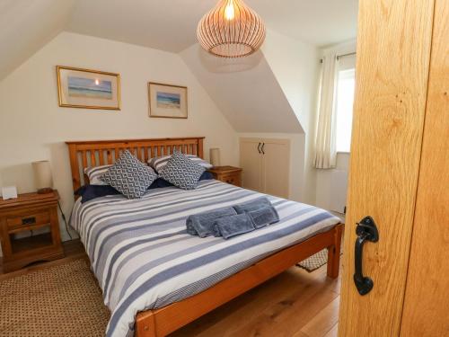 Schlafzimmer mit einem Bett mit blauer und weißer Bettwäsche in der Unterkunft Viking Cottage in Lochailort