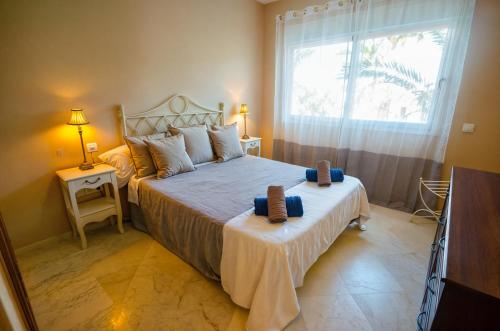 - une chambre avec un grand lit et une fenêtre dans l'établissement Costalita Apartment - Pool by the Beach, à Estepona