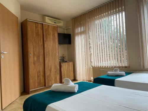 a bedroom with two beds with towels on them at Хотел ЮГ in Primorsko