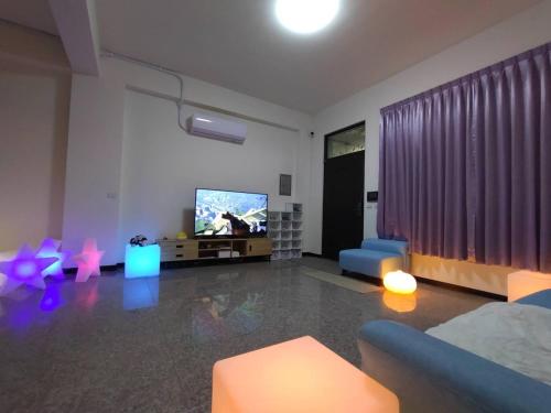 a living room with a couch and a tv at Caiteng B&B in Zhongli