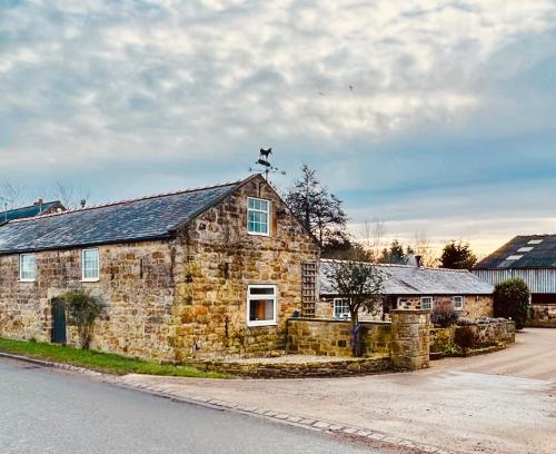 uma casa de pedra ao lado de uma estrada em Twattleton Cottage Kilburn Yorkshire - Beautiful views em York