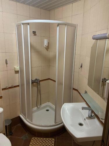 a bathroom with a shower and a sink at Хотел ЮГ in Primorsko