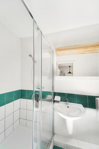La salle de bains est pourvue d'un lavabo et d'une douche. dans l'établissement Hotel Arborétum Harkány, à Harkány