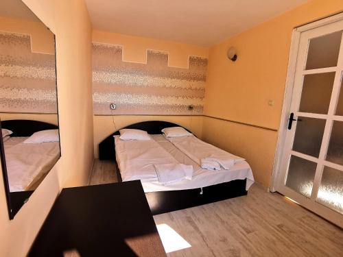 a bedroom with two beds and a window at Family Hotel White House in Pomorie