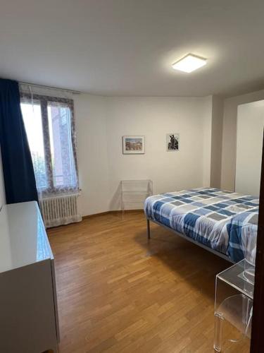 Un dormitorio con una cama y suelo de madera. en Nel cuore della città, en Siena