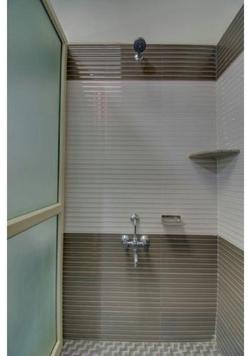 a bathroom with a shower with a faucet at Sriniketana Homestay in Madikeri