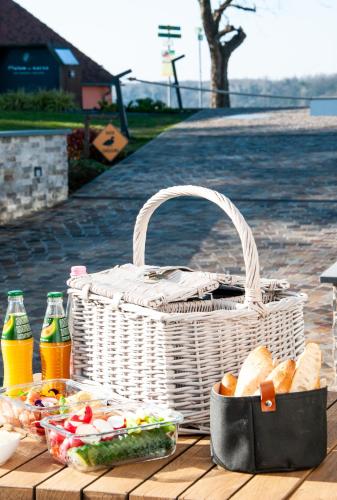 a picnic table with a basket of bread and drinks at Malom és Kacsa Boutique Hotel in Tata