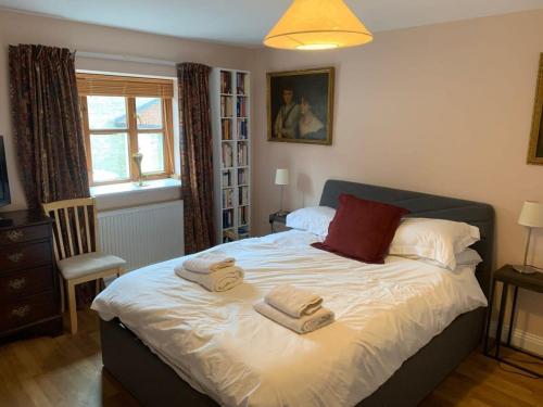 a bedroom with a bed with towels on it at Sweet Modern Country Cottage with Garden in Frome