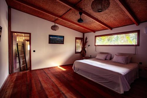 Katiet的住宿－Baha Baha Villa Sailo Mentawai，一间卧室设有一张床和两个窗户。