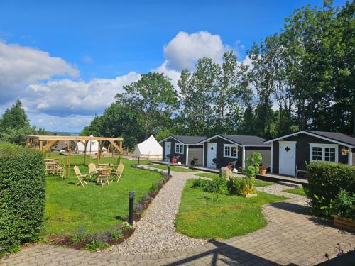 a group of camping cottages with a playground at Kaptenshuset Hotell in Kivik