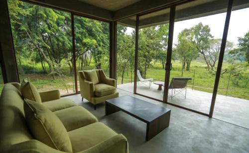 a living room with a couch and chairs and a table at Wild Grass Nature Resort in Sigiriya