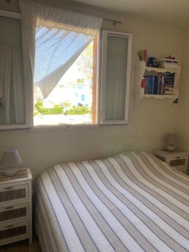 une chambre avec un lit et une fenêtre dans l'établissement PCOGPETS Appartement avec belle vue Marina et piscine à Port-Cogolin, à Cogolin