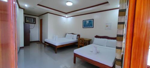 - un salon avec deux lits et un canapé dans l'établissement OYO 1065 Summer Wind Pension, à Puerto Princesa