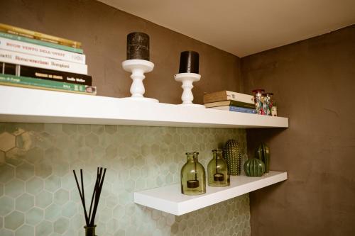 un estante con botellas y velas en la pared en Doma suite 1, en Gela