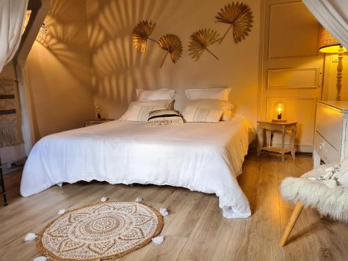 um quarto com uma grande cama branca e um tapete em Gîte de la Besbre em Saint-Pourçain-sur-Besbre